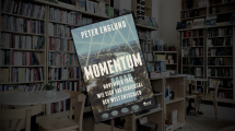 Zu sehen ist ein Buch mit der Aufschrift "Momentum". Im Hintergrund die abgedunkelte Buchhandlung.
