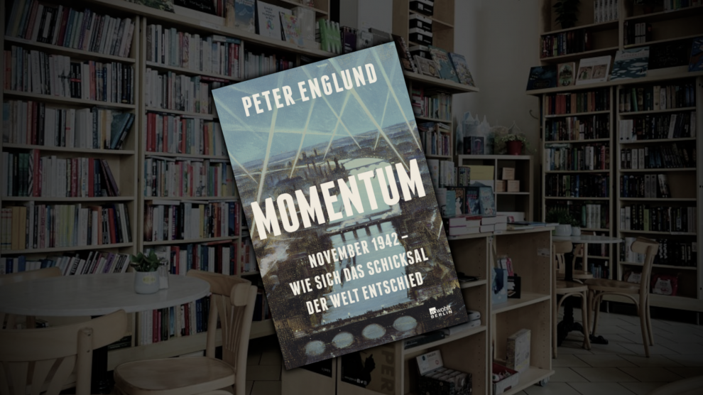 Zu sehen ist ein Buch mit der Aufschrift "Momentum". Im Hintergrund die abgedunkelte Buchhandlung.